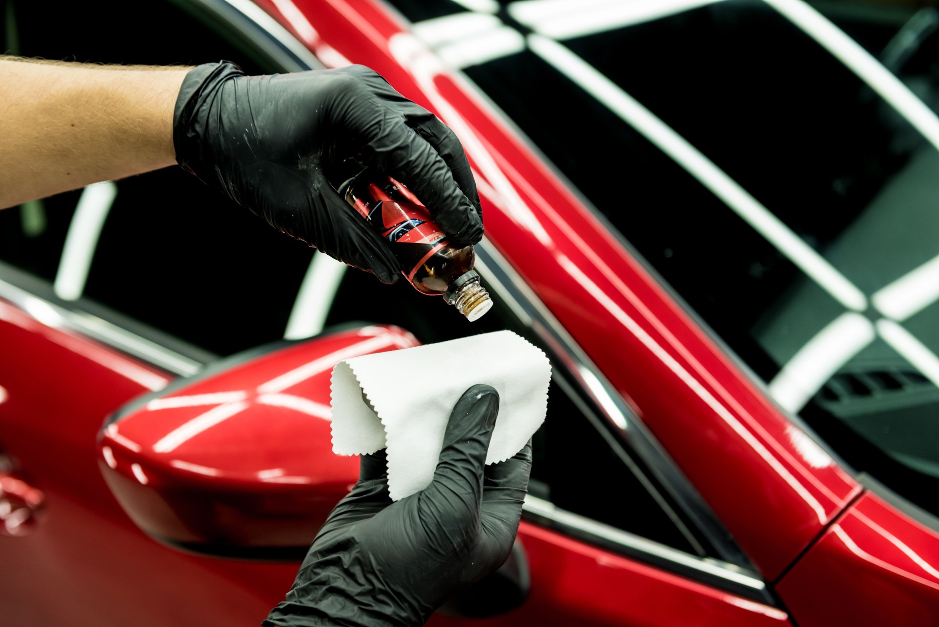 Car service worker applying nano coating on a car.